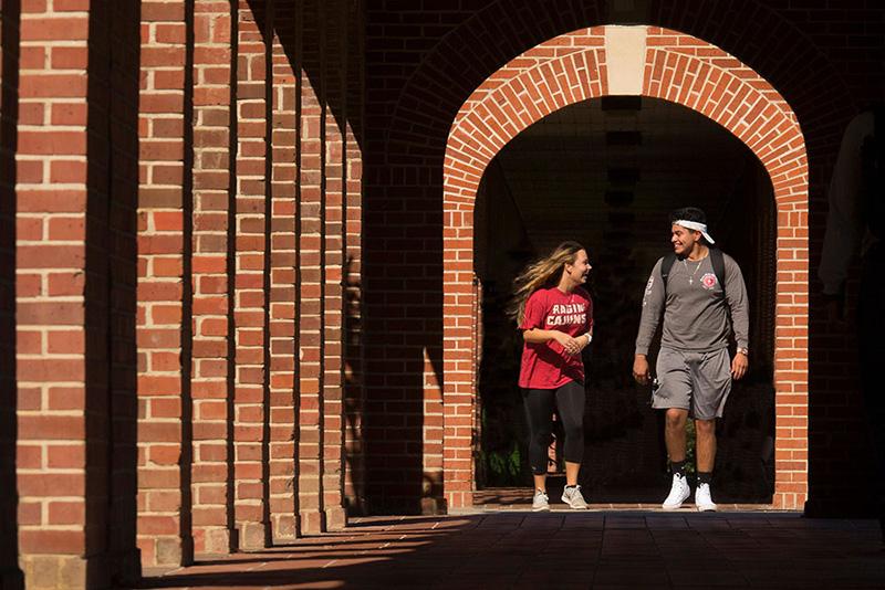 Two Bryman College students walking through the archways on campus