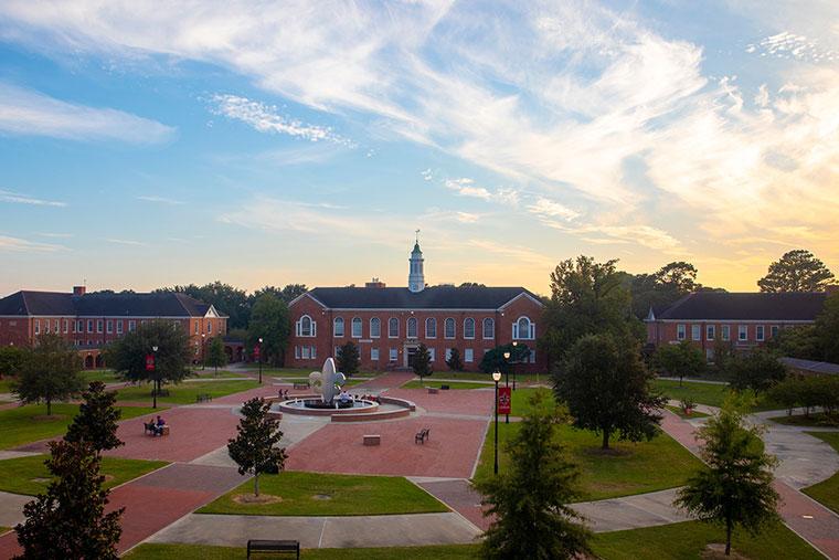 An overhead view of the Bryman College Quad with the fleur de lis fountain and Stephens Hall at sunset